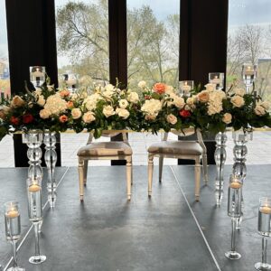 acrylic sweetheart table set up for wedding for bride and groom with flowers and candles