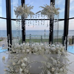 clear arch white florals as backdrop with sweetheart table and white florals at spencers waterfront