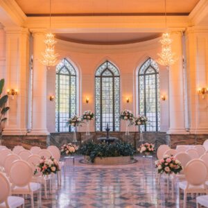 clear plinths white and blush pink floral arrangements on them decorating the aisle Casa Loma conservatory